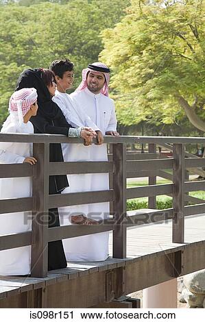 Stock Image - A family standing on a bridge. Fotosearch