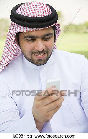 Stock Image - A young man using his cell phone. Fotosearch