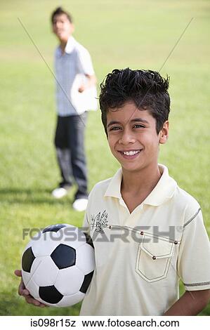 Stock Photo - Portrait of a boy holding a football. Fotosearch