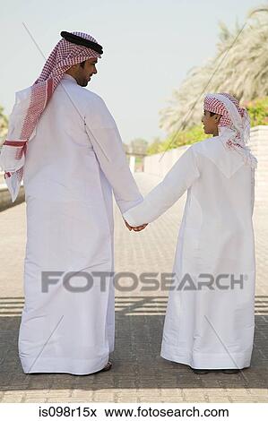 Rear view of a father and son holding hands View Large Photo Image Stock Photo - Rear view of a father and son holding hands. Fotosearch