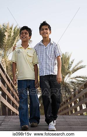 Stock Photo - Two boys walking along a bridge. Fotosearch