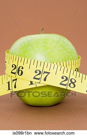 A tape measure wrapped around an apple View Large Photo Image Picture - A tape measure wrapped around an apple. Fotosearch