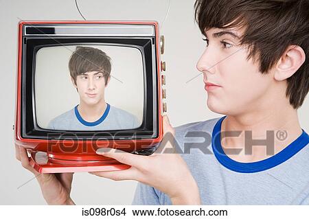 A teenage boy holding a retro tv View Large Photo Image Picture - A teenage boy holding a retro tv. Fotosearch