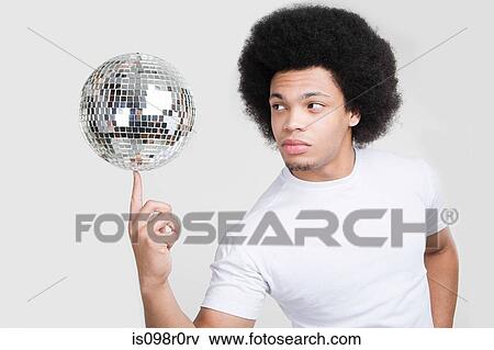 A young man balancing a disco ball View Large Photo Image Stock Photo - A young man balancing a disco ball. Fotosearch