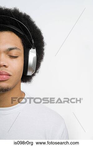 A young man listening to music View Large Photo Image Stock Image - A young man listening to music. Fotosearch