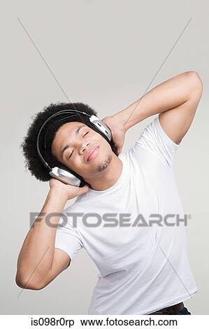 A young man listening to music View Large Photo Image Stock Photography - A young man listening to music. Fotosearch