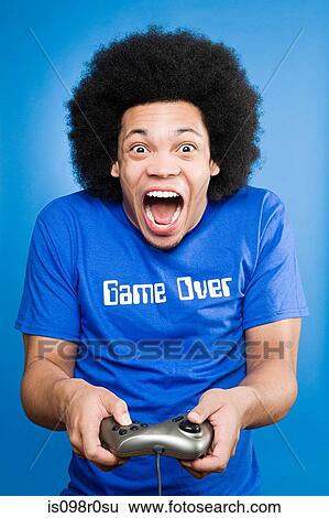 Stock Photograph - A young man playing a video game. Fotosearch