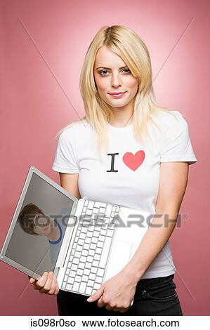 A young woman holding a laptop View Large Photo Image Picture - A young woman holding a laptop. Fotosearch
