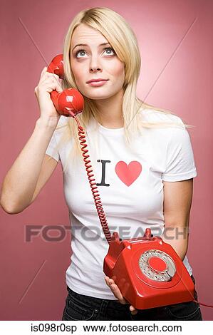 A young woman holding a telephone View Large Photo Image Stock Photography - A young woman holding a telephone. Fotosearch