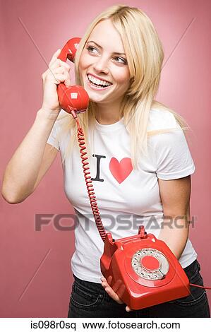 Stock Photography - A young woman holding a telephone. Fotosearch