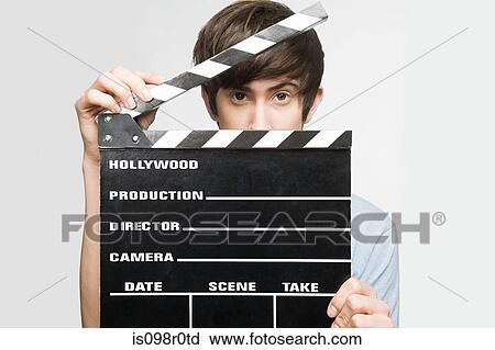 Teenage boy holding a clapperboard View Large Photo Image Stock Image - Teenage boy holding a clapperboard. Fotosearch