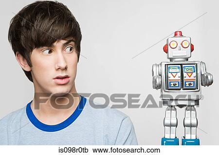 Teenage boy looking at a robot View Large Photo Image Stock Image - Teenage boy looking at a robot. Fotosearch