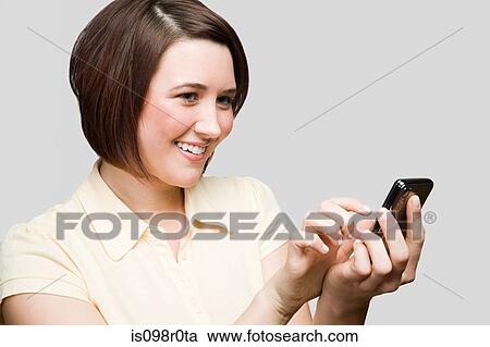 Stock Image - Teenage girl using a cell phone. Fotosearch