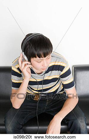Stock Photograph - Young man listening to headphones. Fotosearch