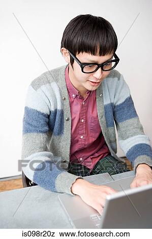 Young man using laptop View Large Photo Image Stock Photo - Young man using laptop. Fotosearch