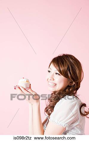 Woman holding cup cake View Large Photo Image Stock Photo - Woman holding cup cake. Fotosearch