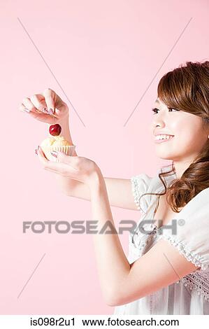 Woman putting cherry on cake View Large Photo Image Stock Image - Woman putting cherry on cake. Fotosearch
