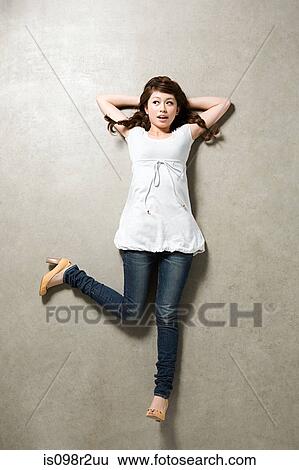 Young woman lying down View Large Photo Image Stock Photograph - Young woman lying down. Fotosearch