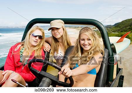 Stock Photo - Friends in vehicle by the coast. Fotosearch