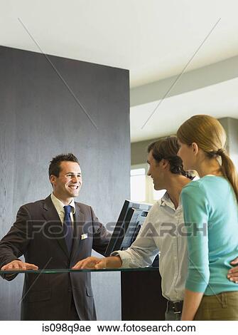 Stock Image - Couple checking into a hotel. Fotosearch