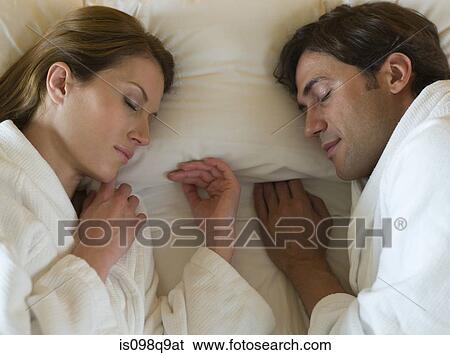 Stock Photograph - Couple sleeping in bed. Fotosearch