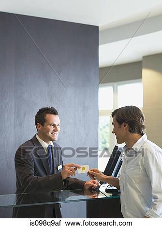 Man checking into a hotel View Large Photo Image Stock Image - Man checking into a hotel. Fotosearch