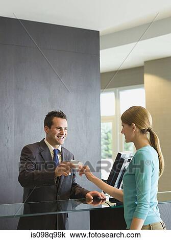Stock Image - Woman checking into a hotel. Fotosearch
