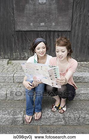 Stock Image - Friends looking at map. Fotosearch