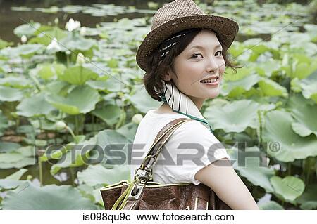 Young woman in garden View Large Photo Image Stock Image - Young woman in garden. Fotosearch