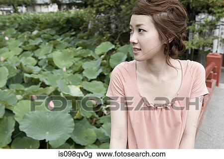 Stock Image - Young woman in garden. Fotosearch