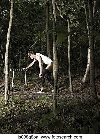 Athlete by hurdle in forest View Large Photo Image Stock Image - Athlete by hurdle in forest. Fotosearch