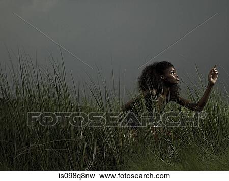 Stock Photo - Female athlete in grass. Fotosearch