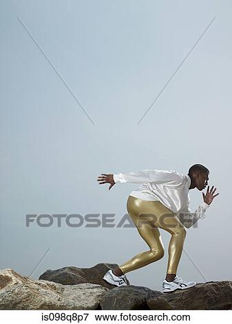 Male athlete on rocks View Large Photo Image Stock Photo - Male athlete on rocks. Fotosearch