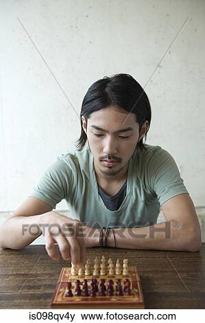 Young man playing chess View Large Photo Image Stock Photo - Young man playing chess. Fotosearch