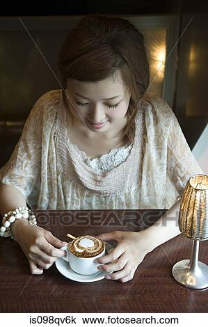 Stock Image - Young woman having coffee. Fotosearch