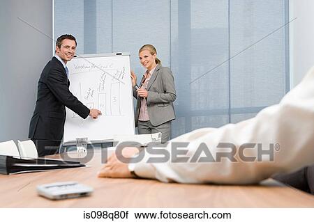 Stock Image - Colleagues giving presentation. Fotosearch