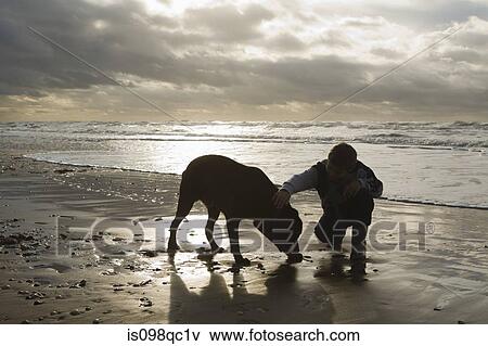 Stock Photo - Boy by sea with dog. Fotosearch