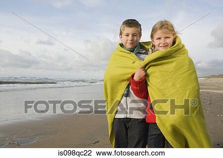 Stock Image - Children in blanket by the sea. Fotosearch