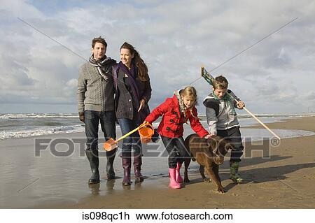 Stock Image - Family and dog by the sea. Fotosearch