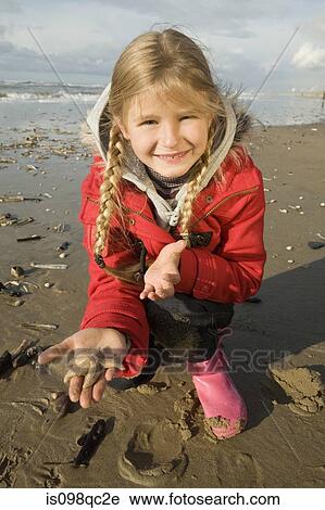Stock Image - Girl at beach with starfish. Fotosearch