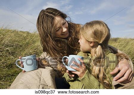 Mother and daughter outdoors with drinks View Large Photo Image Stock Photo - Mother and daughter outdoors with drinks. Fotosearch