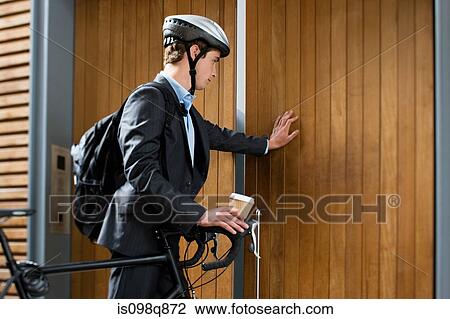 Stock Image - Cyclist opening door. Fotosearch