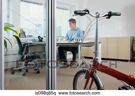 Man in office with bike View Large Photo Image Stock Photography - Man in office with bike. Fotosearch