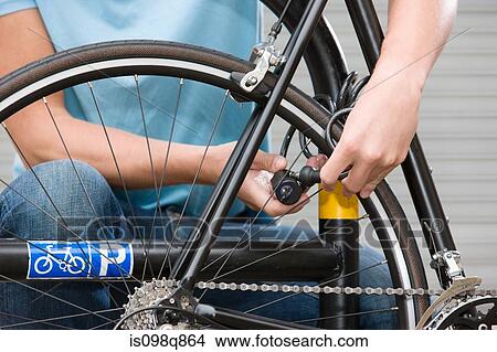 Man locking bicycle View Large Photo Image Picture - Man locking bicycle. Fotosearch