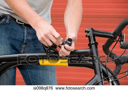 Man locking bicycle View Large Photo Image Stock Photograph - Man locking bicycle. Fotosearch