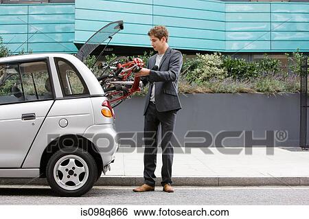 Man putting bicycle in car boot View Large Photo Image Stock Photograph - Man putting bicycle in car boot. Fotosearch