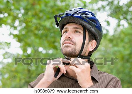 Stock Photo - Man wearing bicycle helmet. Fotosearch
