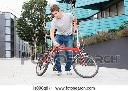 Man with folding bicycle View Large Photo Image Stock Image - Man with folding bicycle. Fotosearch