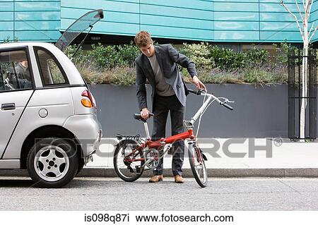 Man with folding bicycle View Large Photo Image Stock Image - Man with folding bicycle. Fotosearch