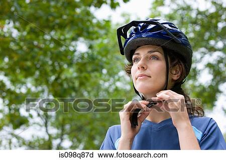 Stock Image - Woman wearing bicycle helmet. Fotosearch